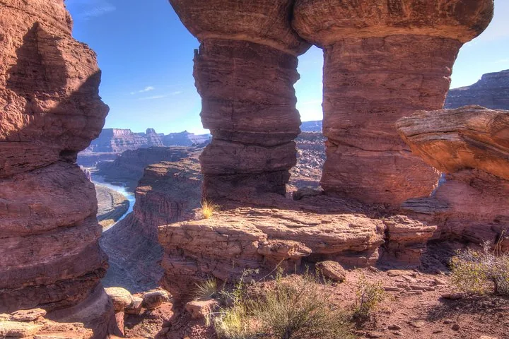 Vista su un canyon fluviale attraverso una finestra formata da pilastri rocciosi naturali